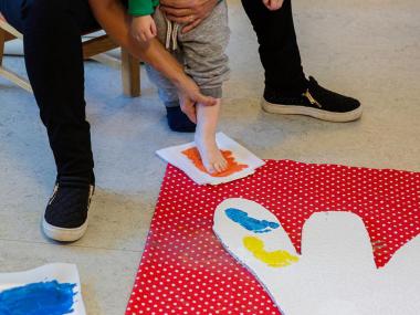 Barnefod sætter fodspor med maling på gulv